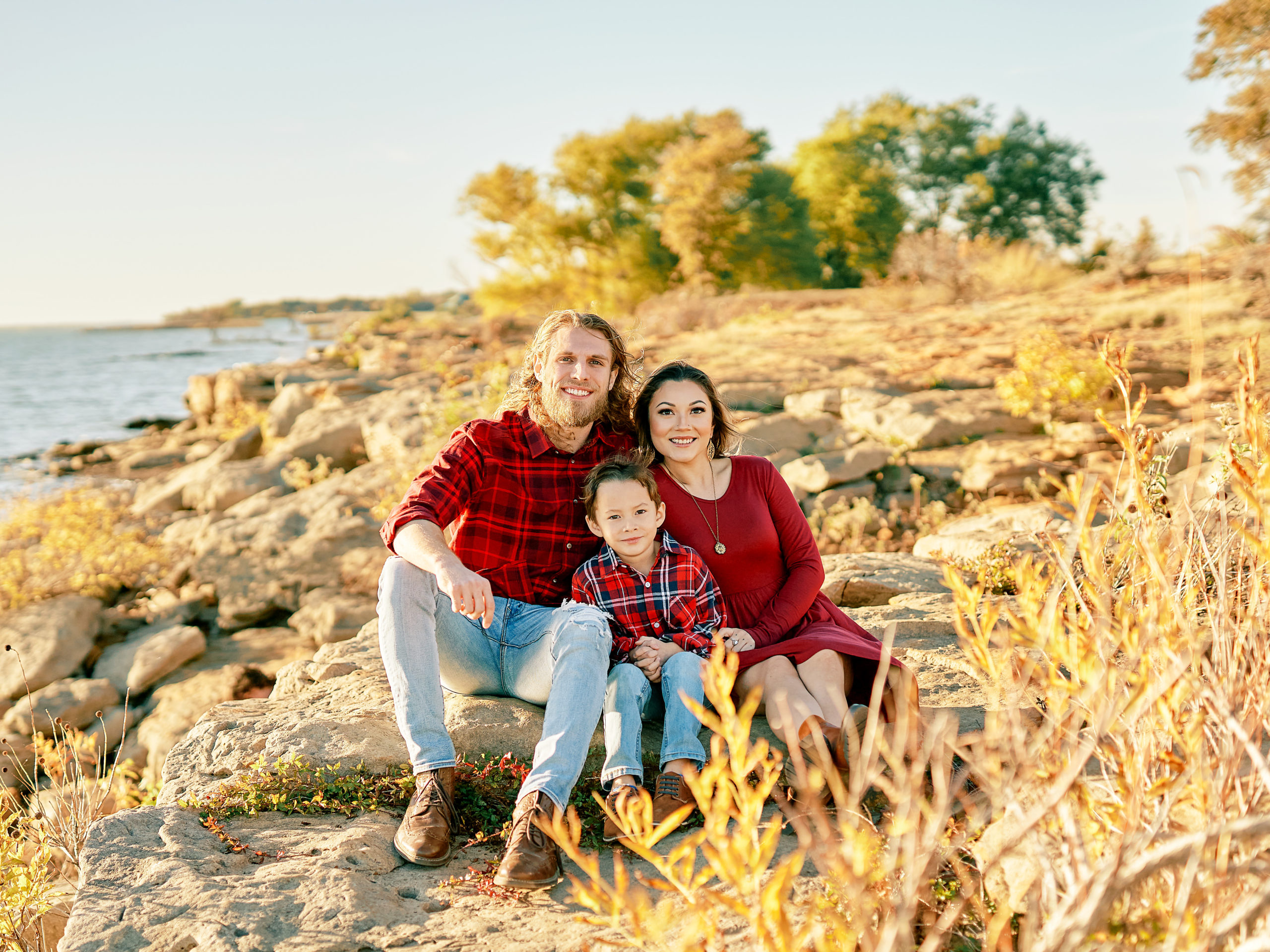 Family of 3 sits on the rocks at Murrell Park in Grapevine Texas