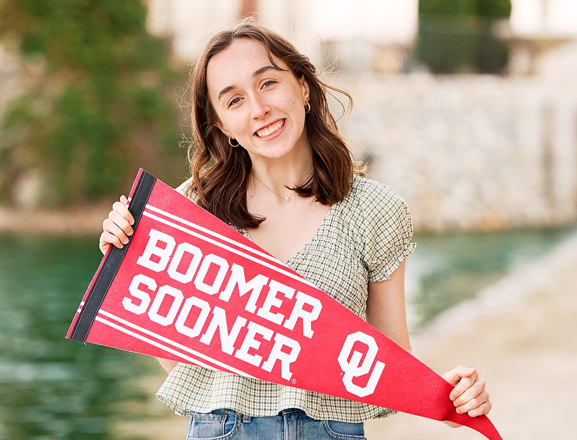 Mckinney Boyd senior posing with her college flag