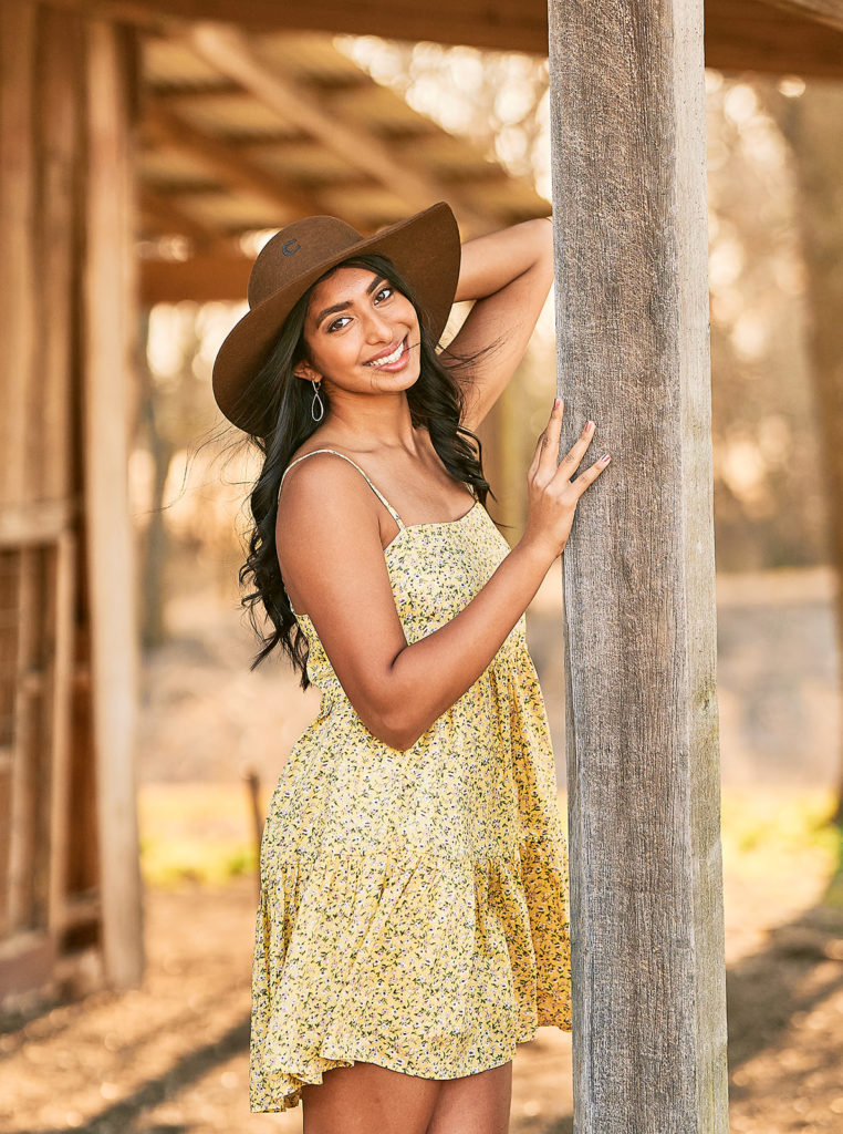 girl posing in a barn for senior pictures