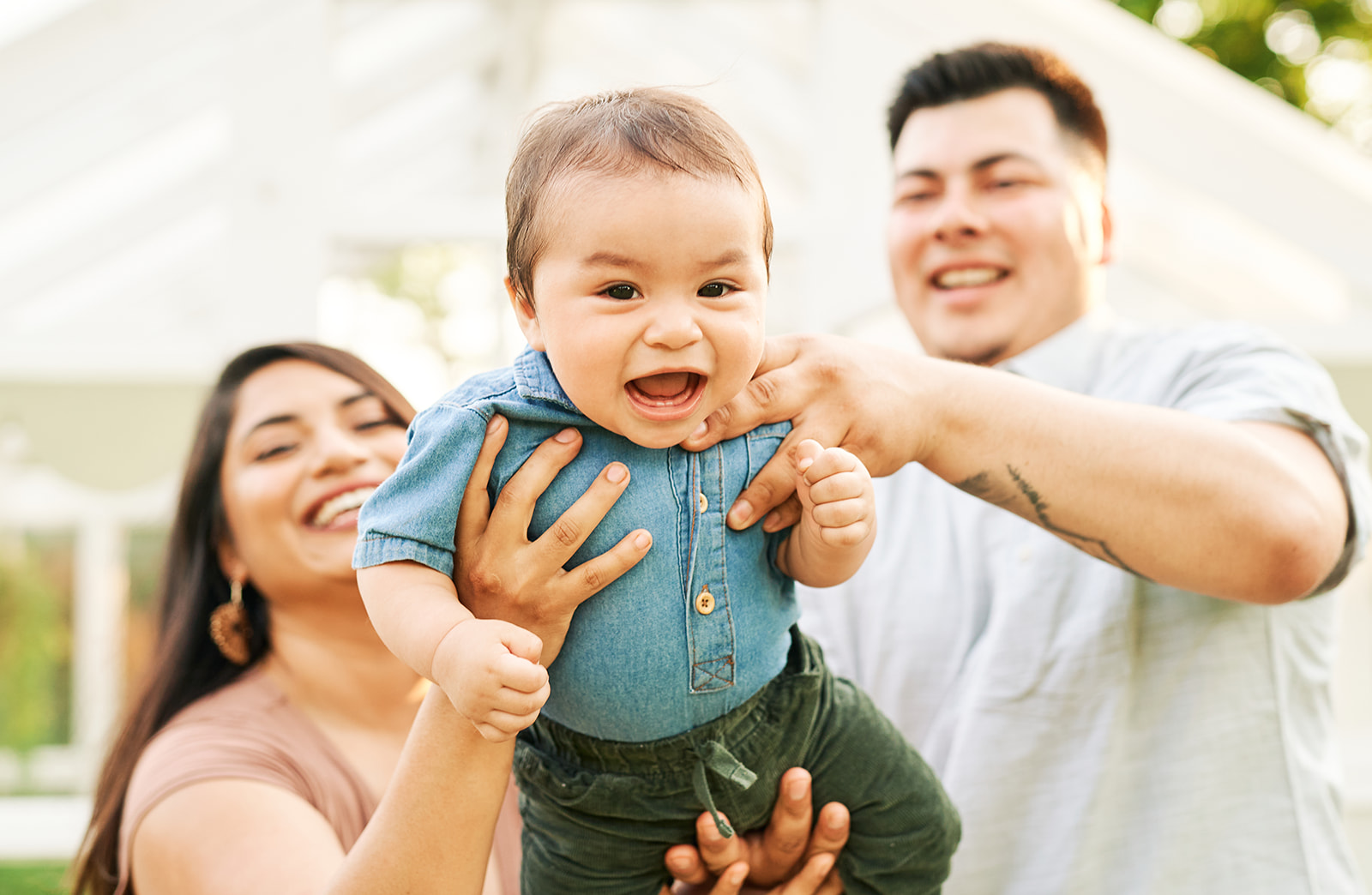 Parents playing airplane with their 8 month old baby boy at a studio in McKinney, TX