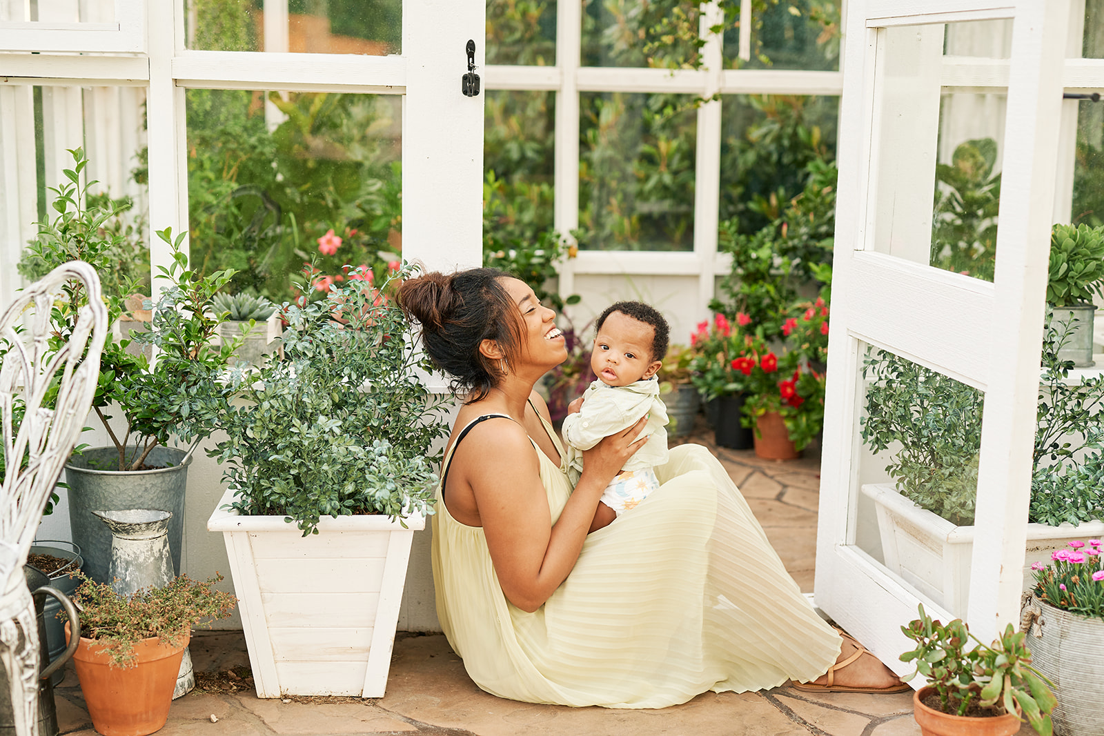 Mother with her baby posing in front of a greenhouse in McKinney, Texas