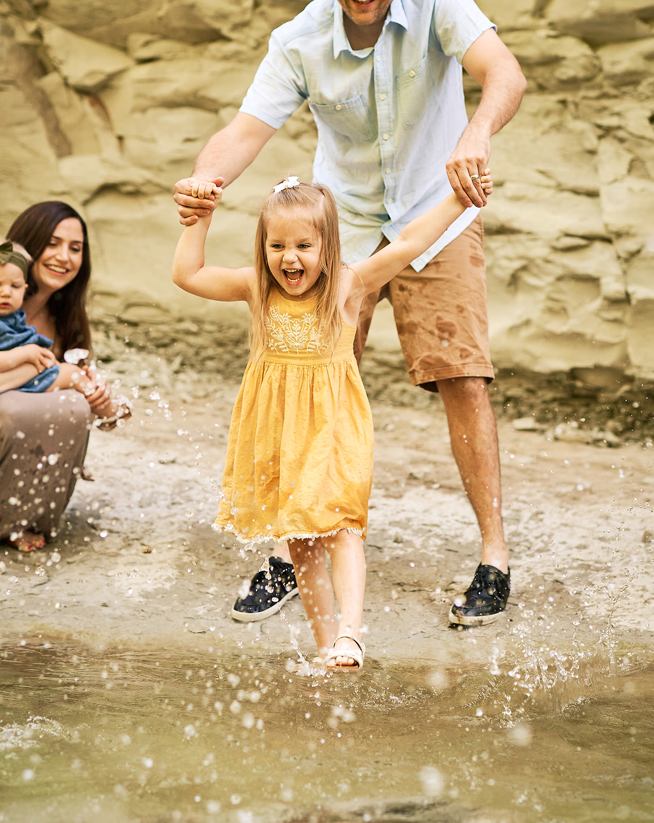 Little girl kicking water at Limestone Quarry Park in Frisco, TX